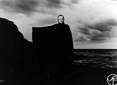 a man standing on top of a rock near the ocean