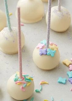 white cake pops with colorful sprinkles and candles on them are ready to be eaten