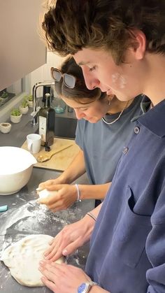 two people in the kitchen making some food