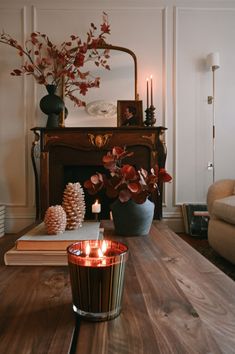 a living room with a fire place next to a couch and a table filled with books