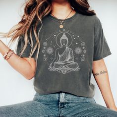 Embrace the tranquility and cosmic beauty of our Meditating Buddha T-Shirt, an ethereal addition to your spiritual wardrobe that transcends the ordinary. Imbued with serenity and the peaceful vibe of Lord Buddha, this celestial tee is more than just clothing; it's a wearable piece of art that speaks to the soul. Crafted from the softest materials, our Buddhist T-Shirt is designed for both comfort and durability. The fabric, a luxurious blend of cotton that feels like a gentle whisper against you Relaxed Fit Graphic Print Tops For Meditation, Casual Graphic Print T-shirt For Meditation, Spiritual Wardrobe, Meditating Buddha, Spiritual Clothing, Lord Buddha, Buddha Meditation, Aesthetic T Shirts, The Soul