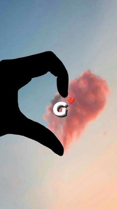 a hand holding an object in the shape of a heart with a cloud behind it