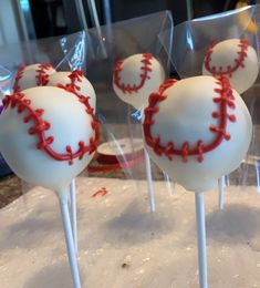 baseball cake pops with red sprinkles on them