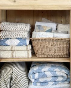 a shelf filled with lots of blankets and pillows