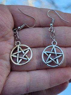 Silver pentacle earrings, pentagram earrings, witchy statement jewelry, alternative fashion accessory, gothic gift ideas for her These pentacle earrings are the perfect gift for anyone in your local coven. Charms are nickel free while the fishhooks are made from sterling silver so they are safer for more sensitive ears. If you would rather have clipons or leverbacks please leave it as a note to seller! Both earrings and my workspace are properly sanitized to ensure your safety during these unpre Gothic Star-shaped Metal Earrings, Gothic Silver Star Earrings, Gothic Star Shaped Metal Earrings, Silver Star Gothic Earrings, Gothic Star-shaped Pierced Earrings, Pentacle Earrings, Pentagram Earrings, Jewelry Alternative, Gothic Gifts