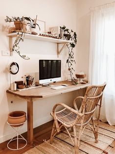 a desk with a computer, chair and potted plant