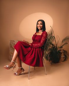 a woman in a red dress sitting on a chair