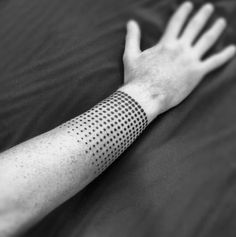 black and white photo of a person's arm with dots on the armband