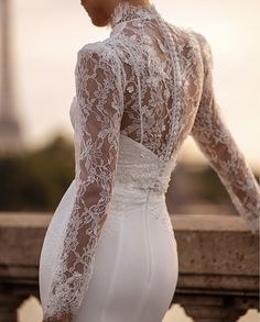 the back of a woman's wedding dress in front of an eiffel tower