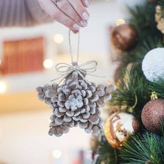 a pine cone ornament hanging from a christmas tree