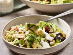 two bowls filled with salad on top of a table