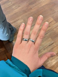 a woman's hand with two rings on it, and one ring is in the middle