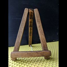 a wooden easel sitting on top of a yellow mat