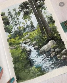 someone is painting a landscape with watercolors on paper and then using colored pencils to draw the scene