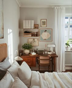 a bedroom with a bed, desk and pictures on the wall