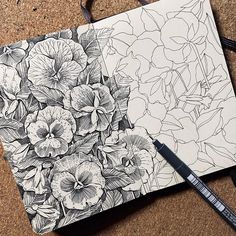 two notebooks with flowers drawn on them sitting on the floor next to each other