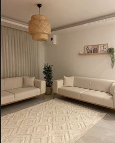 a living room with two couches and a rug in front of a window that has blinds on it