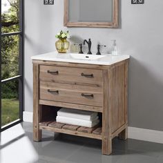 a bathroom vanity with a mirror above it and two towels on the bottom shelf next to it