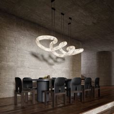 a dining room table and chairs with lights hanging from the ceiling