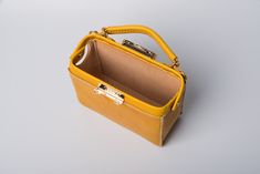 "*DOCTOR BAG'S HANDMADE VIDEO* https://youtu.be/QpdhSCjh2BM Product Description * Material: vegetable tanned leather * Color: Hand-dyeing yellow * Flap over entry with buckle closure ,a rounded projection on the, please press it up to open the flap * 0.75\" wide leather shoulder strap : 110cm * Sewn by hand; * Size: 140mm (H) x 170mm (W) x 70mm (D) / 5.5\" x 6.7\" x 2.7\" Please first look at the production process of our product. 1. The vegetable tanned leather is made in Italy: Vegetable tanni Yellow Office Bag With Top Carry Handle, Yellow Top Handle Box Bag For Office, Luxury Yellow Rectangular Bucket Bag, Yellow Square Box Bag With Top Carry Handle, Office Yellow Shoulder Bag With Detachable Handle, Yellow Office Bag With Detachable Handle, Trendy Yellow Leather Box Bag, Yellow Rectangular Phone Bag For Everyday, Leather Pouch Box Bag With Top Carry Handle