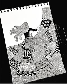 a black and white drawing of a woman with long hair in a dress on a spiral notebook