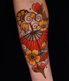 a woman's arm with an umbrella and flowers tattooed on the side of it