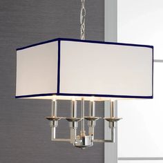 a chandelier hanging from the ceiling with a white and blue shade on it