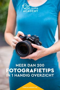 a woman holding a camera with the words meet dan 200 fotografiits in hand overzicht