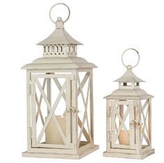 two white lanterns with candles inside each one and an open candle holder on the other