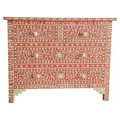 an ornate red and white chest of drawers