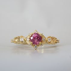 Step into a world of magic and wonder with the Spellbound Sapphire Ring. This enchanting piece, featuring a breathtaking pink sapphire set on a setting that symbolizes shooting stars. This ring is designed to captivate the hearts of those who believe in the beauty of fantasy. With its whimsical charm and exquisite craftsmanship, this ring is a true testament to the allure of fairy tales. All orders come in our Tippy Taste ring box. This ring is handmade and designed in NYC. 14K or 18K solid gold Heirloom Pink Sapphire Ring, Luxury Gold Ring With Pink Sapphire, Heirloom Pink Sapphire Sapphire Ring In Yellow Gold, Heirloom Pink Sapphire Ring In Yellow Gold, Heirloom Yellow Gold Pink Sapphire Ring, Luxury Pink Sapphire Ring In 14k Gold, Pink Sapphire Diamond Ring, Sapphire Diamond Ring, Shooting Stars