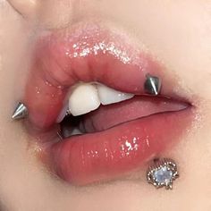 a woman's lips and nose with piercings on top of her lip,