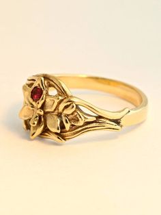 This detailed Orchid Ring is cast in solid 14K gold. A 2.5mm ruby is set in the center of the flower and the leaves of the orchid flow around the finger to form the band. It is 1/3 of an inch wide and rests flat against the finger. We will contact you to let you know if we have your chosen ring size in stock or when to expect shipment. All Marty Magic Jewelry is packaged in a beautiful ring box embossed with the gold foil Marty Magic dragon logo. Perfect for any occasion! Designed in Santa Cruz, Flower-shaped Yellow Gold Ruby Ring For Wedding, Flower Shaped Ruby Ring In Yellow Gold For Wedding, Yellow Gold Flower Ruby Ring For Wedding, Yellow Gold Birthstone Flower Ring, Yellow Gold Ruby Ring For Wedding With Flower Shape, Heirloom 14k Gold Hallmarked Flower Ring, Gold Flower Ruby Ring, 14k Gold Flower Shaped Gemstone Rings, 14k Gold Hallmarked Flower Promise Ring