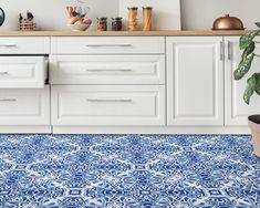 a kitchen with blue and white tile flooring next to a potted houseplant