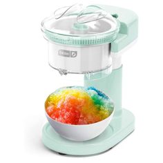 a bowl filled with gummy bears sitting on top of a stand next to a blender