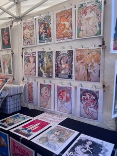 a table topped with lots of posters next to a white tent