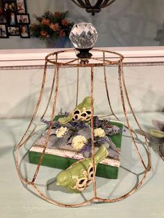 a bird cage with some flowers inside of it