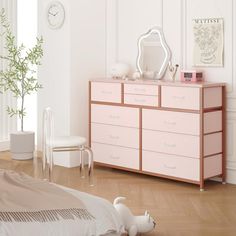 a bedroom with a pink dresser and white walls