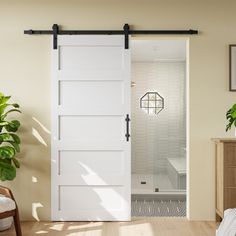 an open door leading to a bathroom with a plant in the corner and potted plants on the floor