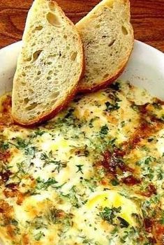 an omelet with bread in it on a wooden table next to a piece of bread