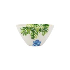 a white bowl with green leaves and blue flowers on the rim, in front of a white background