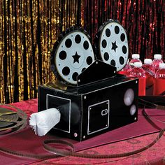 an old fashioned projector sitting on top of a table next to bottles of soda