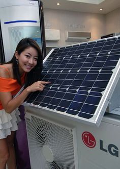 a woman pointing at a solar panel on display