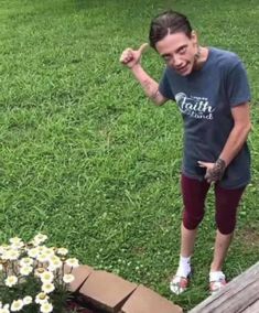 a woman standing in the grass with her fist up and flowers growing out of it