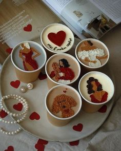 there are many different desserts in cups on the plate with hearts around them and an open book