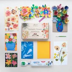 the contents of an art project laid out on a white surface, including flowers and cards