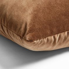 a brown pillow on a white surface