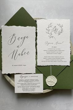 the wedding stationery is set on top of an envelope with a waxed seal