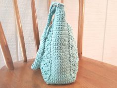 a crocheted purse sitting on top of a wooden chair