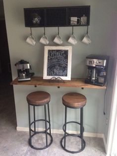 two wooden stools sitting on top of a counter in front of a chalkboard